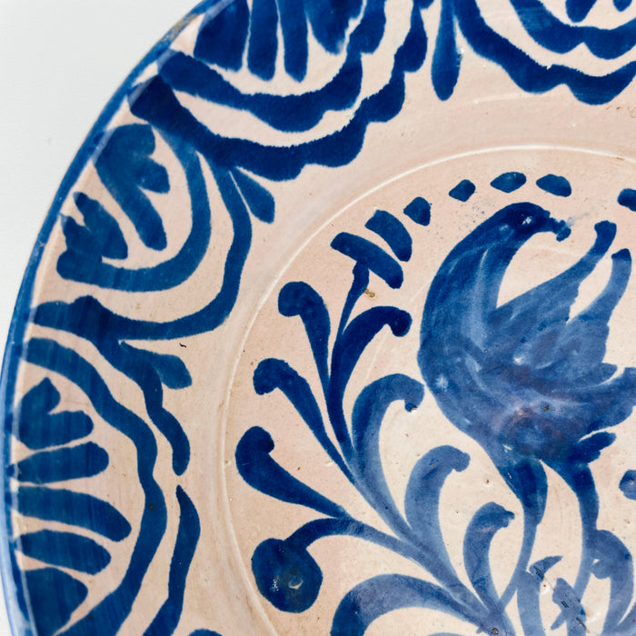cobalt blue heraldic falcon motif on an antique Fajalauza lebrillo from Granada, showing the defined legs, curved beak and sweeping wing, with hand painted scrolls and Moorish-inspired border work, suitable for Mediterranean decor, rustic decor, Japandi, Wabi Sabi and vintage Spanish pottery collections.