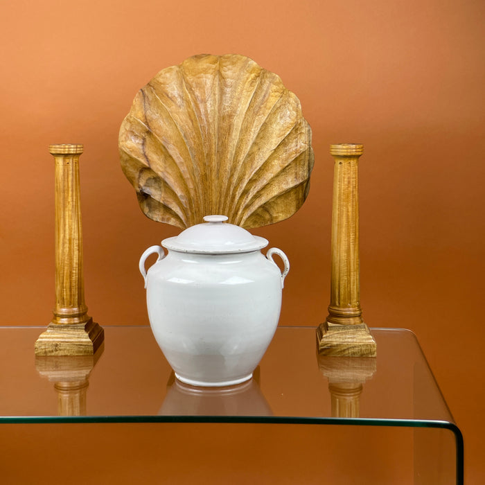 Lifestyle image of antique French white confit pot styled as a centerpiece with decorative wood carvings. Martres Tolosane pottery circa 19th century. Pot à conserve vessel suitable for display as rustic urn or farmhouse French storage jar in modern interiors.
