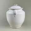 Side view of antique French white glazed confit pot with intact lid, loop handles, and domed cover. Produced in Martres Tolosane, this pot à conserve storage jar embodies French provincial pottery, ideal for farmhouse, wabi-sabi, and Mediterranean decor.
