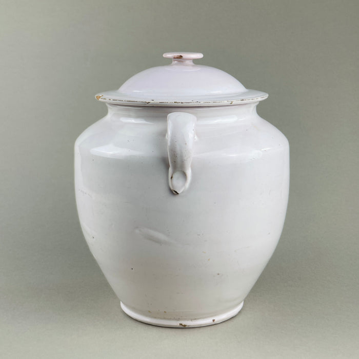 Side view of antique French white glazed confit pot with intact lid, loop handles, and domed cover. Produced in Martres Tolosane, this pot à conserve storage jar embodies French provincial pottery, ideal for farmhouse, wabi-sabi, and Mediterranean decor.