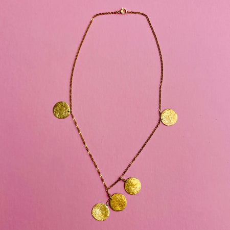 Gold-tone fine link chain necklace with five hammered discs, designed as lightweight artisan jewelry. Each 1.9 cm disc is suspended from a 47.5 cm nickel-free chain with spring-ring clasp. Mediterranean-inspired design makes this a perfect layering necklace or standalone accessory.