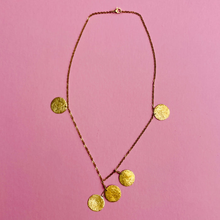 Gold-tone fine link chain necklace with five hammered discs, designed as lightweight artisan jewelry. Each 1.9 cm disc is suspended from a 47.5 cm nickel-free chain with spring-ring clasp. Mediterranean-inspired design makes this a perfect layering necklace or standalone accessory.
