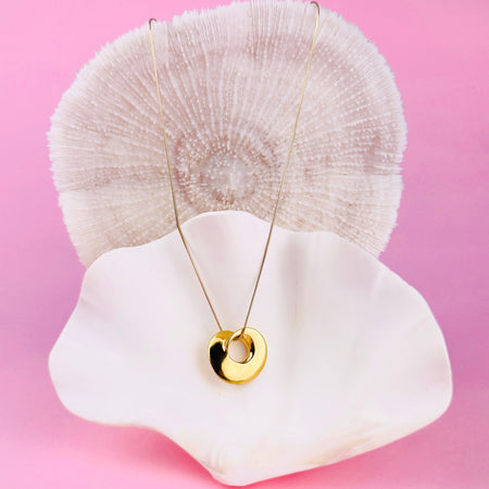 Contemporary gold-plated bronze pendant conceived as wearable art jewelry. This artisan pendant highlights polished golden surfaces and contrasting recessed tones, carved originally in wax by Laragh Stuart and finished using the lost-wax method. Ideal for collectors of sculptural jewelry.