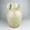 Large antique French white cruche pot from the early 20th century, wheel thrown in glazed terracotta with a rounded body, broad neck, twin loop handles and an applied pouring spout. The cream and ivory surface shows dark mineral specks, age variation and an unglazed foot; the decorative vessel measures 32 cm tall.