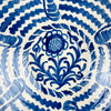 Granada pottery lebrillo bowl with a cream glazed surface and hand painted cobalt blue motifs inside and outside. The interior centers on a sunflower with leafy scrolls and radiating wave bands, while the exterior carries loose elongated blue brushstrokes that echo the handmade decoration. This large Spanish bowl works as wall art, a fruit bowl, or a statement centerpiece for vintage home decor and Spanish decor.