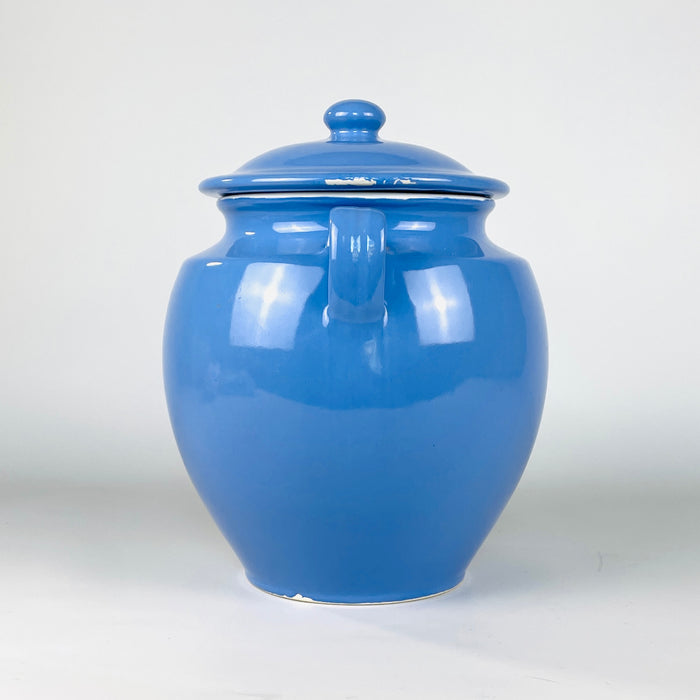 French blue confit pot with the recorded measurements of 28 cm high by 23 cm wide and a weight of 2 kg. The lidded Martres Tolosane faience jar presents a glossy glaze, cream rim, symmetrical loop handles and substantial form suited to farmhouse decor, utensil storage or sculptural display.
