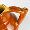 Southwest France pottery water jug with a wheel thrown body and separately applied handle and tubular spout. Dating to the early 20th century, the glazed gargoulette displays reddish brown tones, yellow around the opening, irregular firing marks and surface wear that complement wabi sabi decor.