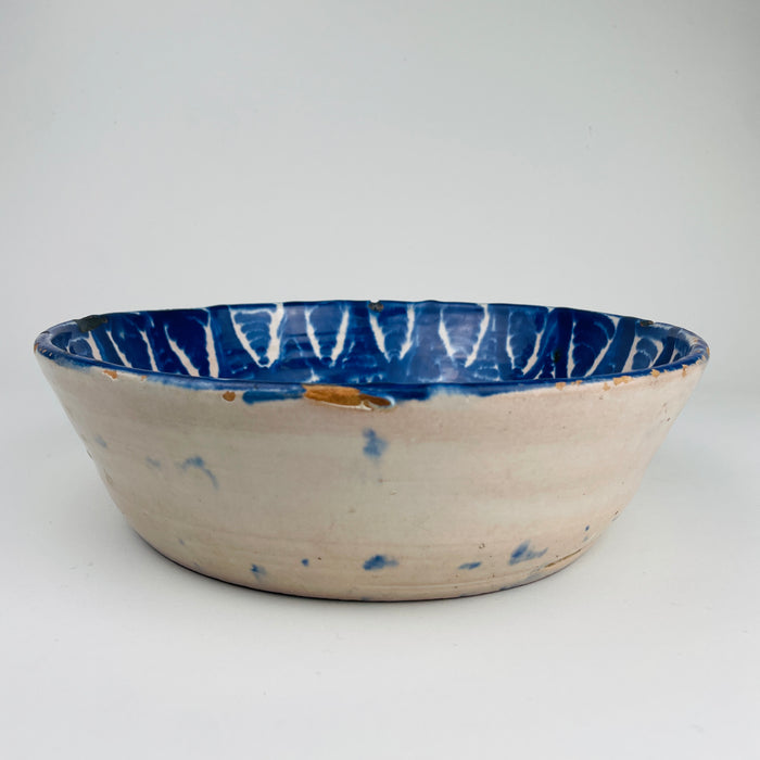 Close-up of cobalt pigment saturation on a 19th-century Fajalauza ceramic wall bowl, showing mineral variation and brush movement unique to hand-painted Andalusian pottery. This artisanal quality aligns with Wabi Sabi decor and Japandi interiors focused on natural imperfection.