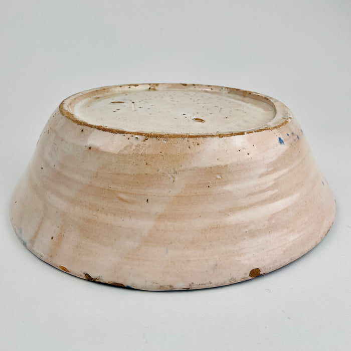 Underside view of the antique Spanish tin-glazed lebrillo, documenting the unglazed foot, terracotta clay tone, and firing marks consistent with traditional Granada production. This Fajalauza pottery bowl is ideal as wall hanging ceramic decor, a table centerpiece, or a serving bowl for Wabi Sabi decor and Japandi interiors that value handmade imperfection.