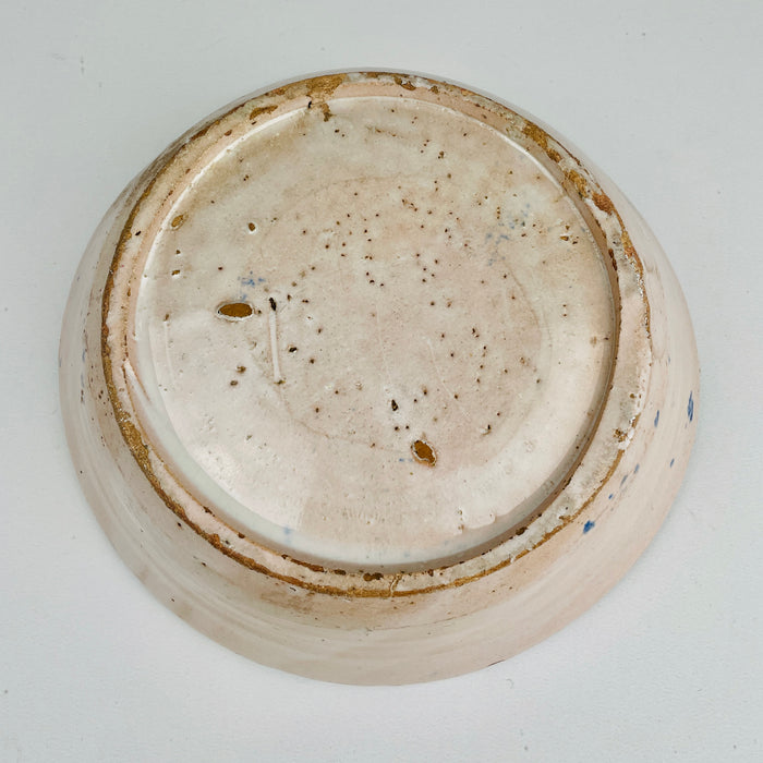 Underside view of the antique Spanish tin-glazed lebrillo, documenting the unglazed foot, terracotta clay tone, and firing marks consistent with traditional Granada production. This Fajalauza pottery bowl is ideal as wall hanging ceramic decor, a table centerpiece, or a serving bowl for Wabi Sabi decor and Japandi interiors that value handmade imperfection.