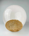 Antique French white confit pot from Martres Tolosane with an unglazed circular base revealing the warm buff earthenware beneath the ivory exterior. Wear, kiln texture and darkened marks on the foot document the hand-finished construction and long working life of this early 20th century faience storage jar.