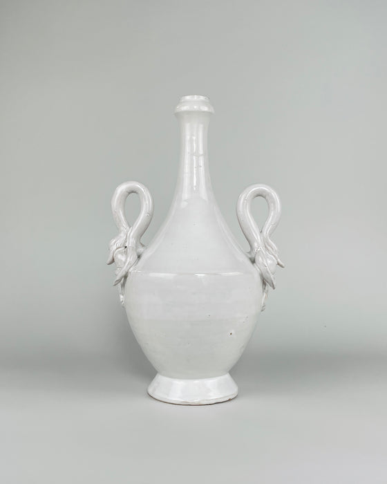 Vintage large Italian white ceramic vase from the mid 20th century, measuring 36 cm tall and 22 cm wide, with a glossy ivory glaze, rounded amphora body, long tapered neck, pedestal foot and two sculptural swan handles. The symmetrical form combines classical Mediterranean influence with decorative Renaissance Revival and neo Baroque details.