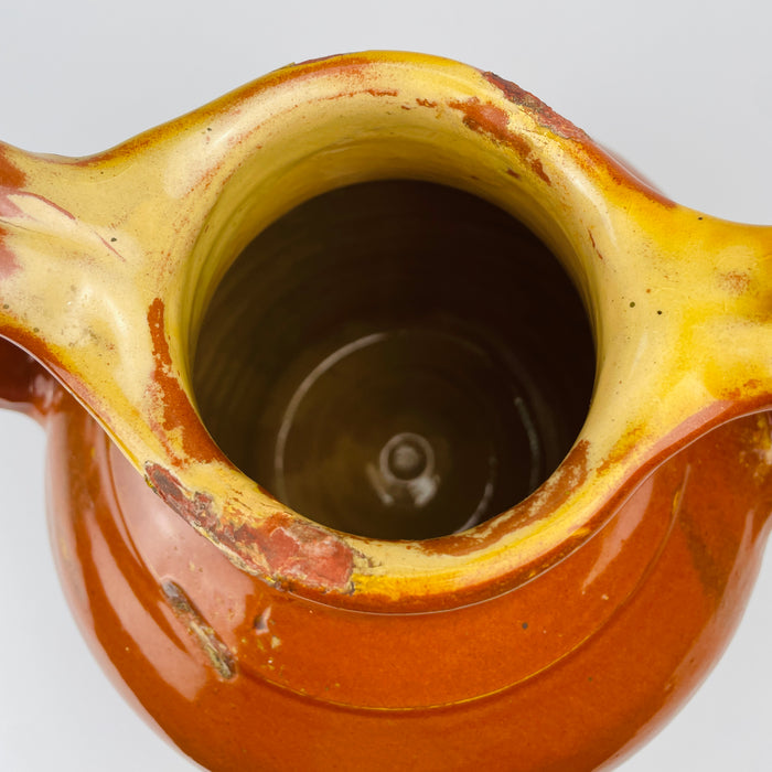Large French gargoulette pot in brown glazed terracotta, originally made for carrying, storing and pouring household water. Its full rounded belly and unusual twin arched profile create a bold decorative vessel for French country decor, while worn edges and glaze losses retain the character of everyday rural use.
