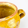 French antique pottery jar identified as a confit pot, with yellow glaze, earthenware construction, and a balanced country silhouette. The vessel shows age-related glaze loss, a softly worn rim, and handmade character throughout the body. Its authentic antique surface makes it appealing for rustic decor, farmhouse interiors, and collectors of French pottery and terracotta storage jars.