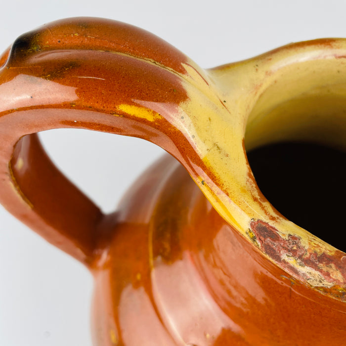 Antique terracotta water vessel from southern France with the distinctive construction of a large gargoulette. The central mouth was used to fill the pot, while the hollow bridge shaped spout directed the water. Its warm rust and ochre palette works naturally with Mediterranean decor and collected regional ceramics.