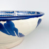 The broad circular scale of this Spanish Fajalauza bowl emphasizes its substantial presence as a decorative object. Hand painted cobalt blue waves, a central sunflower, and scrolling foliage fill the white glazed interior, while the traditional lebrillo depth gives the piece sculptural volume. It works as statement wall art, a fruit bowl, or a large table centerpiece for Mediterranean decor and vintage home decor.