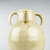 French cruche pot dating to the early 20th century, defined by two balanced loop handles rising from the shoulders to the wide neck. The hand-applied handles show subtle tool marks, glaze variation and age wear, adding authentic surface character to this large white pottery jug for cottage decor.