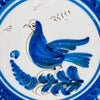 Central decoration on the Spanish Talavera wall plate depicts a stylized cobalt blue bird standing over a plume shaped branch, outlined and feathered with fine manganese brown strokes. The motif sits within double blue rings on a white tin glazed ground, giving this antique faience bird plate a clear focal point for botanical wall art.