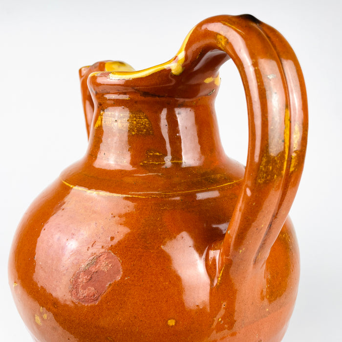 Early 20th century French gargoulette made as a household water pot, with a rounded earthenware body and pronounced raised attachments. Glossy rust brown glaze pools across the shoulder and neck, while chips reveal the clay beneath, creating an authentic aged patina suited to wabi sabi decor and vintage home decor.