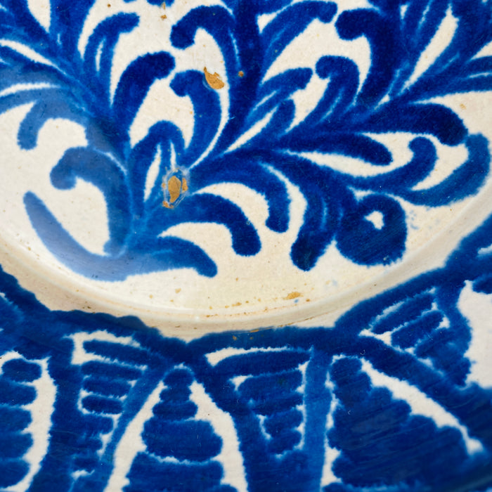 Exterior view of the antique Fajalauza earthenware bowl, showing firing marks and cobalt splashes that confirm traditional kiln production. These natural imperfections enhance its appeal for Wabi Sabi decor, while its scale allows use as decorative wall art or table centerpiece in rustic and coastal homes.