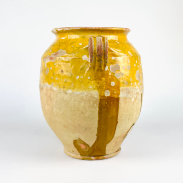 French terracotta confit pot with antique yellow glaze, showing the sculptural ovoid body and practical storage jar form associated with old French kitchen pottery. The vessel displays pronounced wear, glaze losses, and age-softened texture across the shoulder and rim. As an antique pottery jar, it fits farmhouse decor, rustic decor, and Mediterranean decor with authentic character