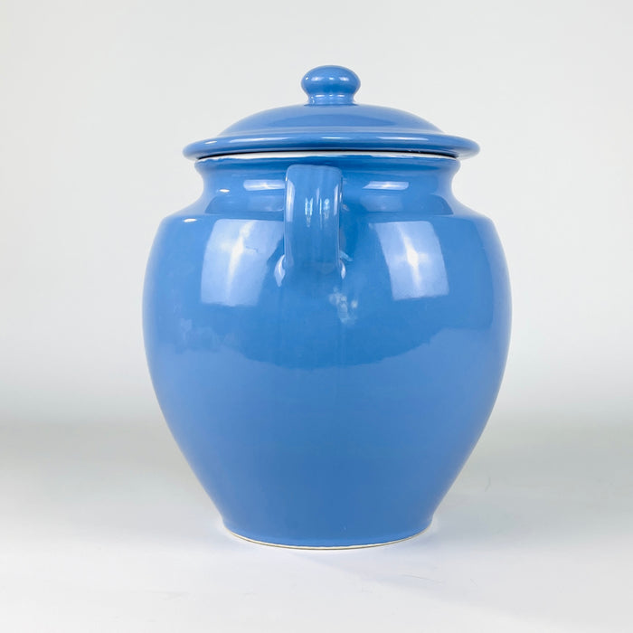 French blue confit pot with the recorded measurements of 28 cm high by 23 cm wide and a weight of 2 kg. The lidded Martres Tolosane faience jar presents a glossy glaze, cream rim, symmetrical loop handles and substantial form suited to farmhouse decor, utensil storage or sculptural display.