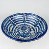 Hand painted Spanish lebrillo bowl in the Fajalauza tradition, made in glazed earthenware with a broad open shape and classic blue and white palette. The bowl combines a floral center with concentric painted bands and works well as a fruit bowl, table centerpiece, or wall display. It suits Spanish decor, farmhouse decor, cottage decor, and vintage kitchen styling.