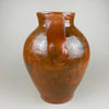 Rear view of the antique terracotta pot, highlighting the twin handles, glaze runs, and subtle color shifts from firing—brown, ochre, and red clay tones. This decorative pottery vessel can anchor a console or open shelf, aligning with rustic home decor, farmhouse decor, and collected ceramic displays.