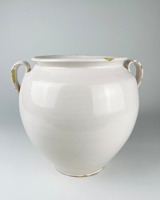 White glazed earthenware confit pot from Martres Tolosane, France, dating to the early 20th century. The wheel thrown body retains subtle horizontal making lines, scattered surface marks, small glaze losses and a fine diagonal surface hairline, authentic age details that complement restrained wabi sabi decor.