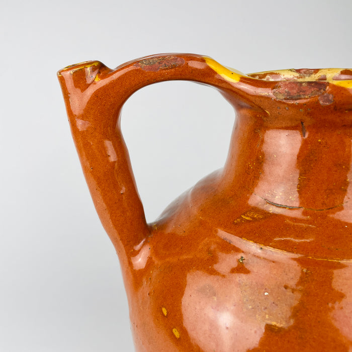 Large French gargoulette pot in brown glazed terracotta, originally made for carrying, storing and pouring household water. Its full rounded belly and unusual twin arched profile create a bold decorative vessel for French country decor, while worn edges and glaze losses retain the character of everyday rural use.