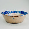 Antique Spanish Fajalauza lebrillo bowl from Granada, hand-thrown tin-glazed earthenware in cobalt blue on a warm cream ground, featuring a central floral bouquet motif and a scalloped rim border. The soft cobalt bleed from kiln firing adds depth and movement. Use as wall hanging ceramic, table centerpiece, or serving bowl for Mediterranean Decor and Rustic Home Decor.