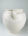 Antique French white confit pot from Martres Tolosane with a generous ovoid body that narrows toward a defined circular foot. Made in glazed earthenware in the early 20th century, the ceramic jar has an opaque cream-white finish, broad rolled lip and balanced loop handles suited to use as a large vase or cottage decor accent.