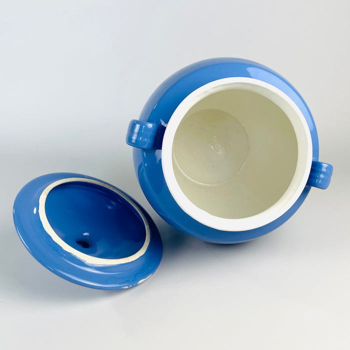 French blue confit pot in glazed faience with a balanced urn-shaped silhouette, small loop handles, rolled neck and broad domed lid. The mid 20th century Martres Tolosane vessel retains the practical form of a pot à graisse while working today as a decorative jar, branch vase or French country decor centerpiece.