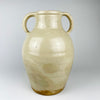 Antique French white cruche with a small impressed numeral on one handle near the rim, preserving evidence of its utilitarian workshop production. The wheel-thrown terracotta body, cream glaze, paired handles and projecting spout combine in a sculptural early 1900s water jug with French provincial character.