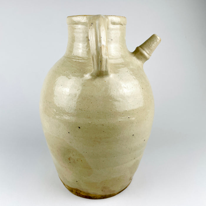 Substantial early 20th century French terracotta jug measuring 32 cm high and 22 cm across the handles, with a weight of 2.9 kg. Its generous scale, full rounded body and pale glazed surface make the antique cruche pot an assertive decorative object for a console, floor display or large shelf.