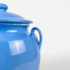Vintage lidded confit pot from southwest France accompanied by tomatoes and green peppers, recalling its original role in the provincial kitchen. The glazed faience vessel has a rounded body, narrow foot, paired handles and bright blue finish, making it a functional storage jar and a strong French kitchen decor accent.