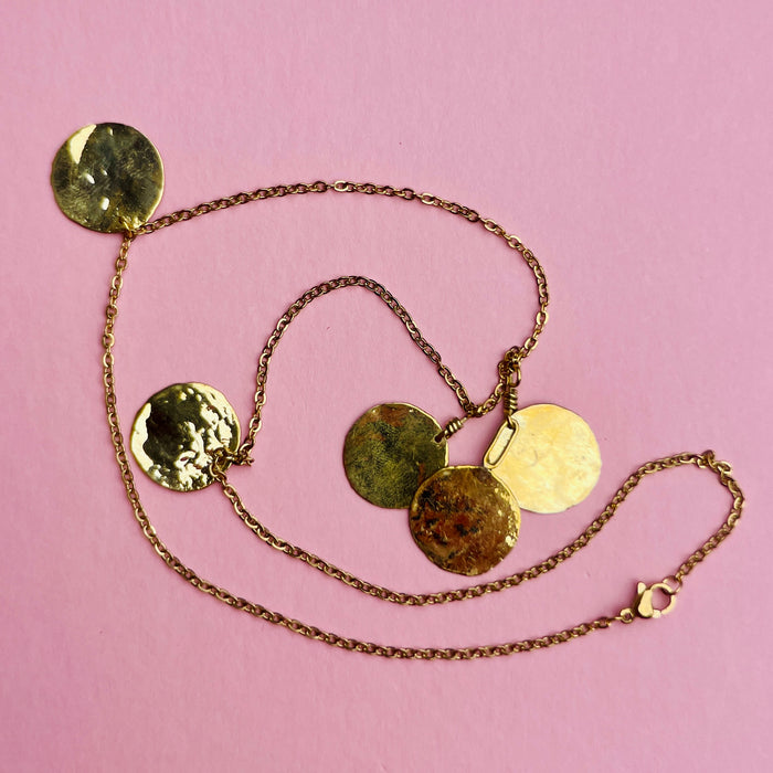 Minimalist gold disc chain necklace with hammered texture, reflecting Mediterranean adornments. The fine link nickel-free chain and golden discs shimmer with movement. Ideal for resort wear, contemporary jewelry styling, and everyday accessorizing.