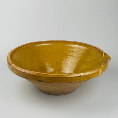 Large antique French terracotta tian bowl with deep yellow slip glaze, showing aged patina and provincial craftsmanship from Occitanie and Provence pottery traditions. Works beautifully in wabi-sabi and French country kitchens as a sculptural serving bowl or decorative centrepiece, adding texture and earth-tone authenticity to curated spaces.