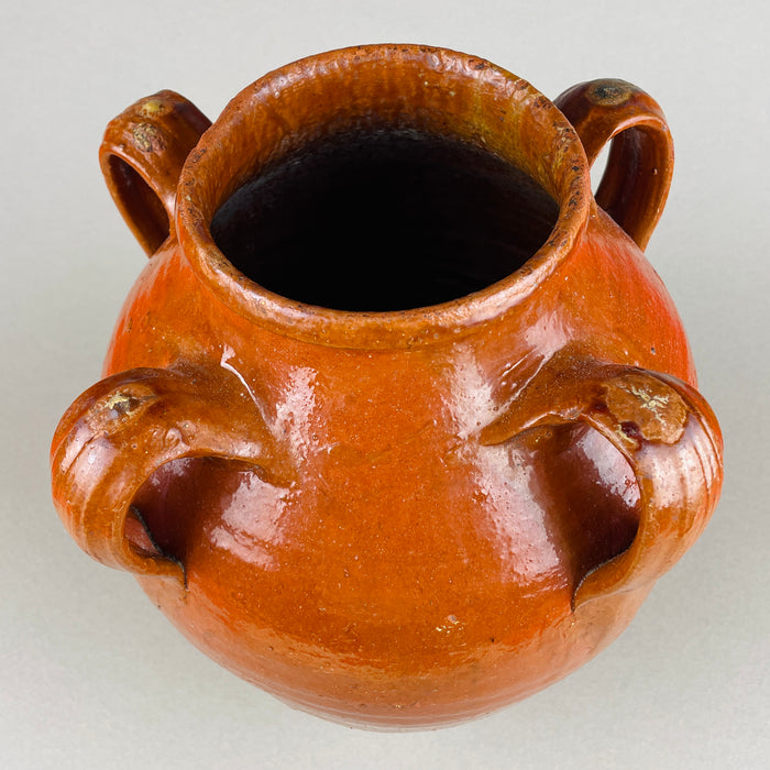 Large antique Spanish terracotta jar displayed in an interior setting with wall art, emphasizing its architectural silhouette and earthy tone. A timeless piece of Mediterranean pottery ideal for styling rustic, eclectic, or organic interiors as a sculptural accent.