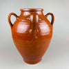 Side profile of a large antique Spanish earthenware jar showing the iron-oxide glaze and balanced proportions. The four-handled orza design and artisanal glaze drips emphasize its handmade construction, suitable for Mediterranean kitchen styling rustic home decor.