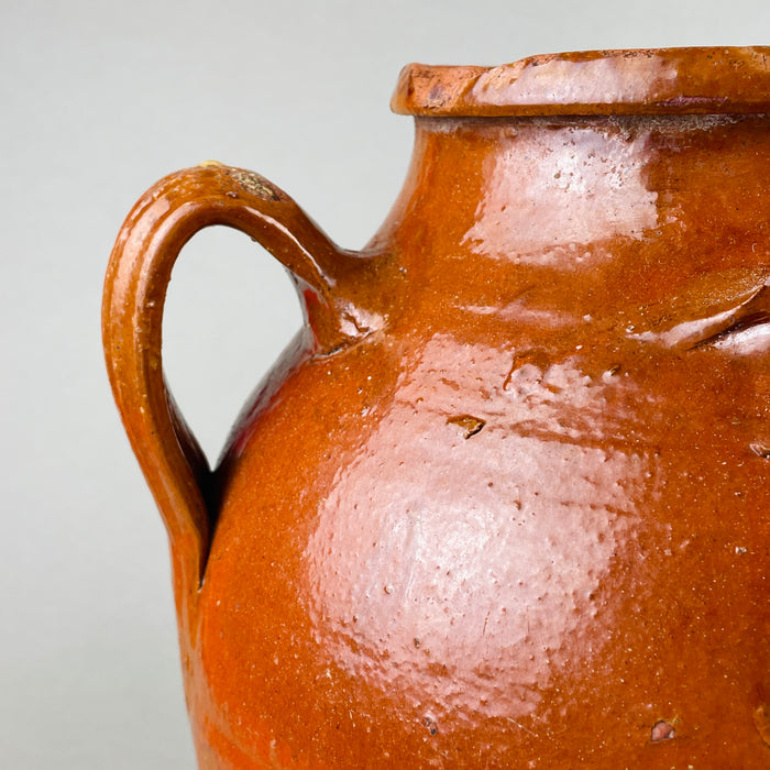 Rear view of a Toledo terracotta orza illustrating the natural glaze variations, warm earthy tone, and subtle throwing rings typical of Castilian pottery. This antique Spanish vessel makes an ideal decorative accent for organic modern or Mediterranean interiors.