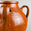 Detailed close-up showing the textured red glaze and curved handle attachments of the antique Spanish orza, capturing the craftsmanship and firing imperfections that authenticate its handmade origin. Ideal for collectors of Mediterranean ceramics and wabi sabi styling.