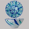 Vintage Fajalauza pottery bowl from Granada, Spain, a tin glazed terracotta lebrillo with opaque white glaze and hand-painted cobalt blue and copper green decoration. The interior shows a radial rosette with geometric vegetal panels, while rim wear and chips expose terracotta, suitable for Mediterranean decor serving and display.