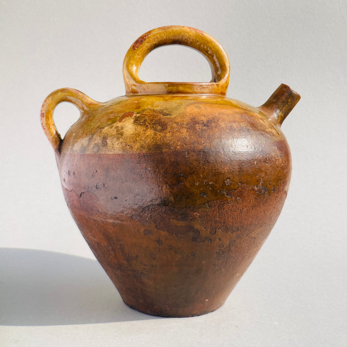 Collector’s ceramic piece from 1800s France featuring curved handles and distinctive functional spout.