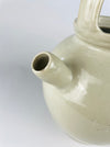French terracotta water cruche with a narrow applied spout projecting from the upper shoulder between two handles. The cream glaze pools and changes tone around the handmade join, with an old hairline and small glaze losses visible at the attachment; this age detail is part of the antique vessel’s condition.