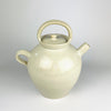 Large antique French white cruche pot from the early 20th century, wheel thrown in glazed terracotta with a rounded body, broad neck, twin loop handles and an applied pouring spout. The cream and ivory surface shows dark mineral specks, age variation and an unglazed foot; the decorative vessel measures 32 cm tall.