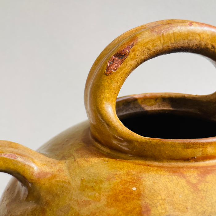 Top handle and spout form casting strong shadows, emphasizing vintage curves and symmetry.