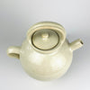 Early 1900s French cruche pot formed on a potter’s wheel from fired clay and covered in an irregular cream glaze. The broad cylindrical neck, symmetrical loop handles and small projecting spout identify its traditional household vessel form, while its generous scale gives this antique pottery strong decorative presence.