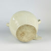 Antique French white cruche with a small impressed numeral on one handle near the rim, preserving evidence of its utilitarian workshop production. The wheel-thrown terracotta body, cream glaze, paired handles and projecting spout combine in a sculptural early 1900s water jug with French provincial character.