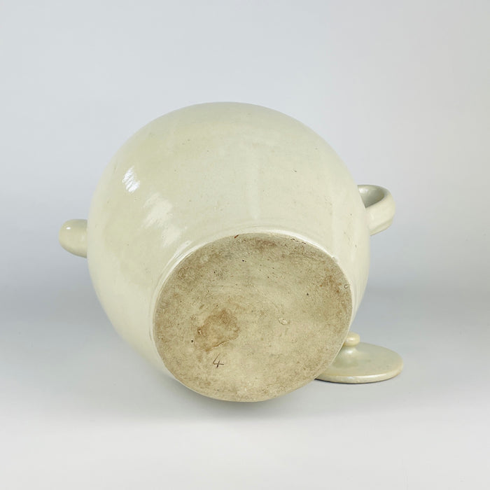 Antique French white cruche with a small impressed numeral on one handle near the rim, preserving evidence of its utilitarian workshop production. The wheel-thrown terracotta body, cream glaze, paired handles and projecting spout combine in a sculptural early 1900s water jug with French provincial character.